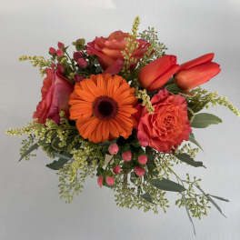 Bouquet of orange gerbera daisies, coral roses, and red tulips