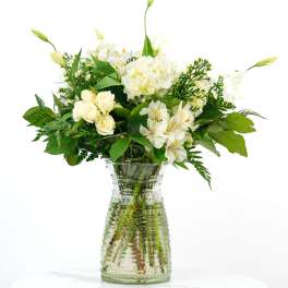 White flowers arranged in a clear glass vase