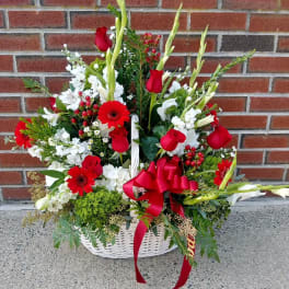 Basket arrangement of red roses, white flowers, and a red ribbon