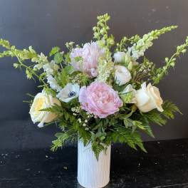 Pink and white floral arrangement in a ribbed white vase