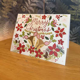 Christmas card with deer and red floral decorations