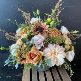 Peach and white floral arrangement in a gray vase