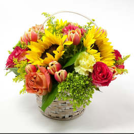Basket arrangement with sunflowers, tulips, and roses