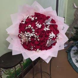 Bouquet of red roses with white baby's breath in pink wrap