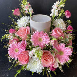 Pink and white floral wreath around a gray candle holder
