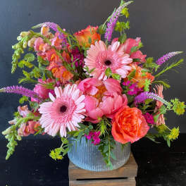 Bright pink and orange mixed bouquet in a ribbed metal container