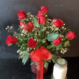 Red roses in a red vase with a glittery heart pick and ribbon