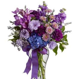 Purple mixed bouquet in a clear glass vase with ribbon
