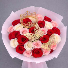 Bouquet of red, pink, and white roses with gold crown and butterfly accents