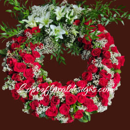 Heart-shaped wreath of red roses and white lilies with baby's breath