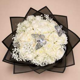 Round bouquet of ivory roses with baby's breath and silver butterflies in black wrap