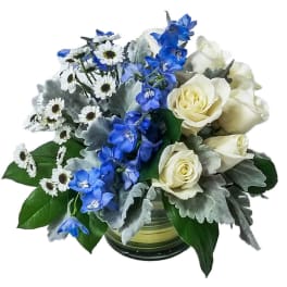 Blue and white flowers arranged in a glass vase
