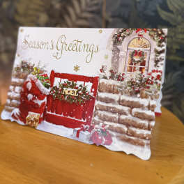 A Christmas greeting card with a red door and holiday decorations