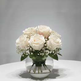 White roses arranged in a clear glass vase