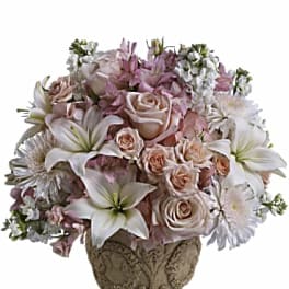 Pink and white floral arrangement in an ornate vase