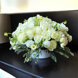 White rose and chrysanthemum arrangement in a low white vase