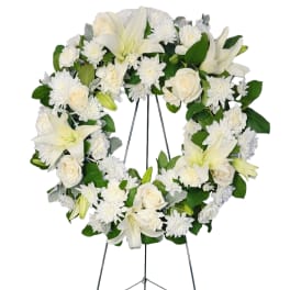 White floral wreath on a metal easel stand