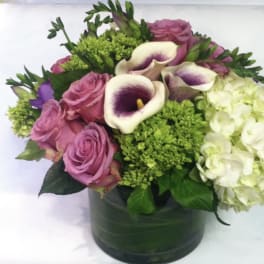 Pink roses and white calla lilies in a green vase