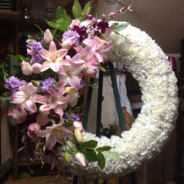 Large crescent floral wreath with pink lilies and white blooms