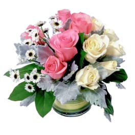 Pink and white roses in a glass vase with small white daisies