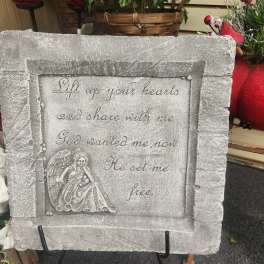 Stone memorial plaque with an angel relief and engraved verse