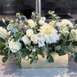 White roses and dahlias in a gold rectangular vase with blue accents