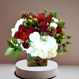 Red roses and white orchids in a square glass vase