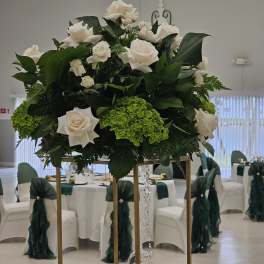 Large white rose arrangement on a tall gold stand