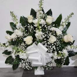 White rose and chrysanthemum arrangement with a large white bow