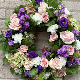 Circular floral wreath with pink, purple, and white blooms
