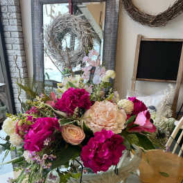 Large mixed bouquet with pink and cream flowers in a white basket