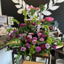 Purple and pink floral arrangement with roses and chrysanthemums