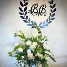White and green floral arrangement in a white vase