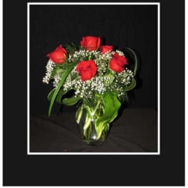 Red roses in a glass vase with baby's breath