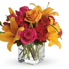 Bouquet of pink roses and orange lilies in a clear glass vase