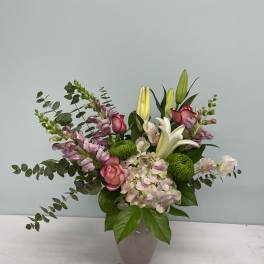 Mixed bouquet with pink roses, lilies, hydrangea, and green mums in a vase