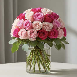 Pink and white roses arranged in a clear glass vase