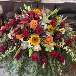 Large mixed flower arrangement with roses, lilies, and sunflowers