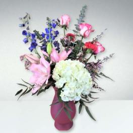 Mixed bouquet in a pink vase with lilies, roses, and hydrangea