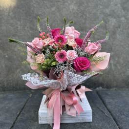 Pink mixed bouquet with roses, gerbera daisies, and carnations wrapped in ribbon