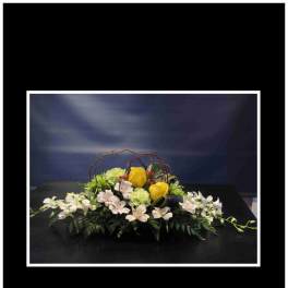 Low floral centerpiece with yellow roses and white orchids