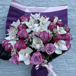 Bouquet of pink roses and white orchids wrapped in purple paper