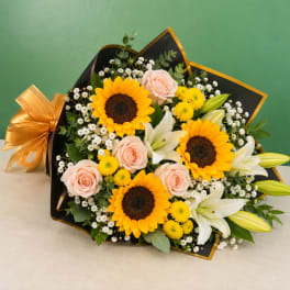 Bouquet of sunflowers, pale roses, white lilies, and yellow mums