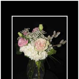 Pink and white roses with hydrangea in a clear glass vase