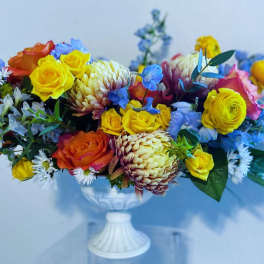 Colorful mixed bouquet in a white pedestal vase