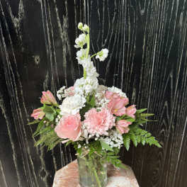Pink and white floral arrangement in a glass vase