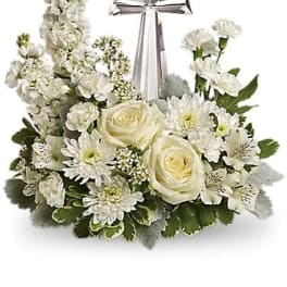 White floral arrangement with a silver cross centerpiece
