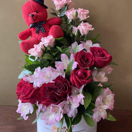 Red teddy bear with pink roses and red roses in a white box