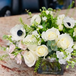 White roses and anemones arranged in a glass vase