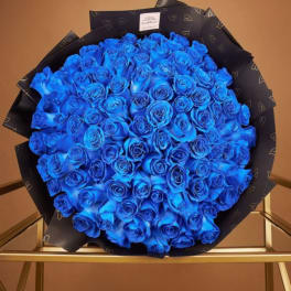 Large bouquet of vivid blue roses wrapped in black paper